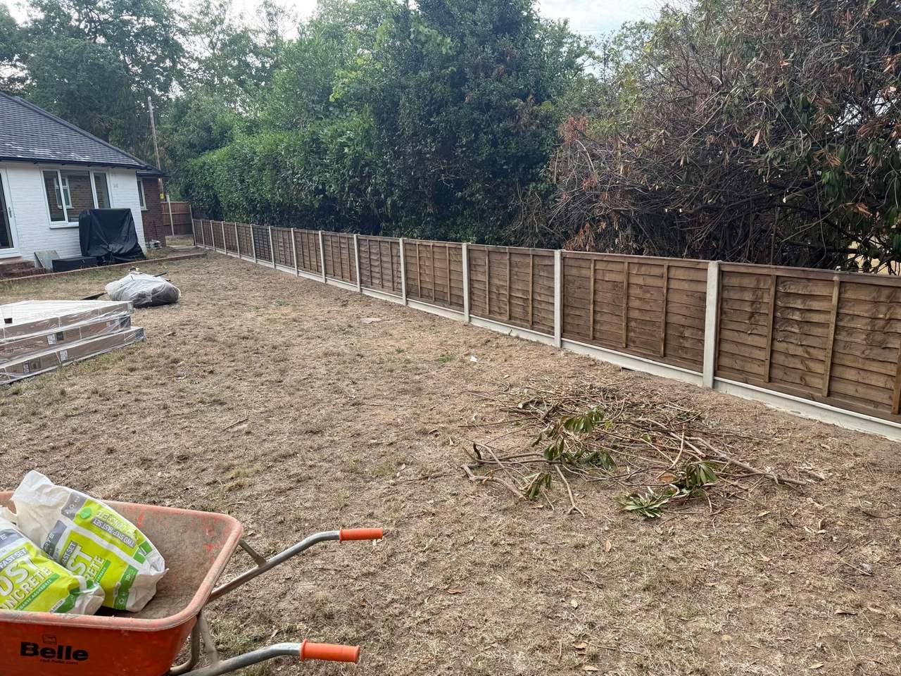 Back garden stripped back to bare soil with new lap fence panels along two boundaries