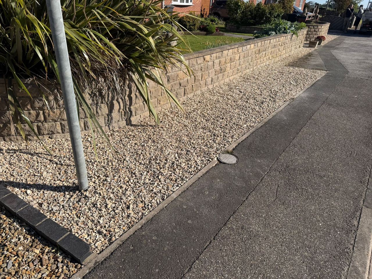 Gravel border with stone edging beside a planted bed