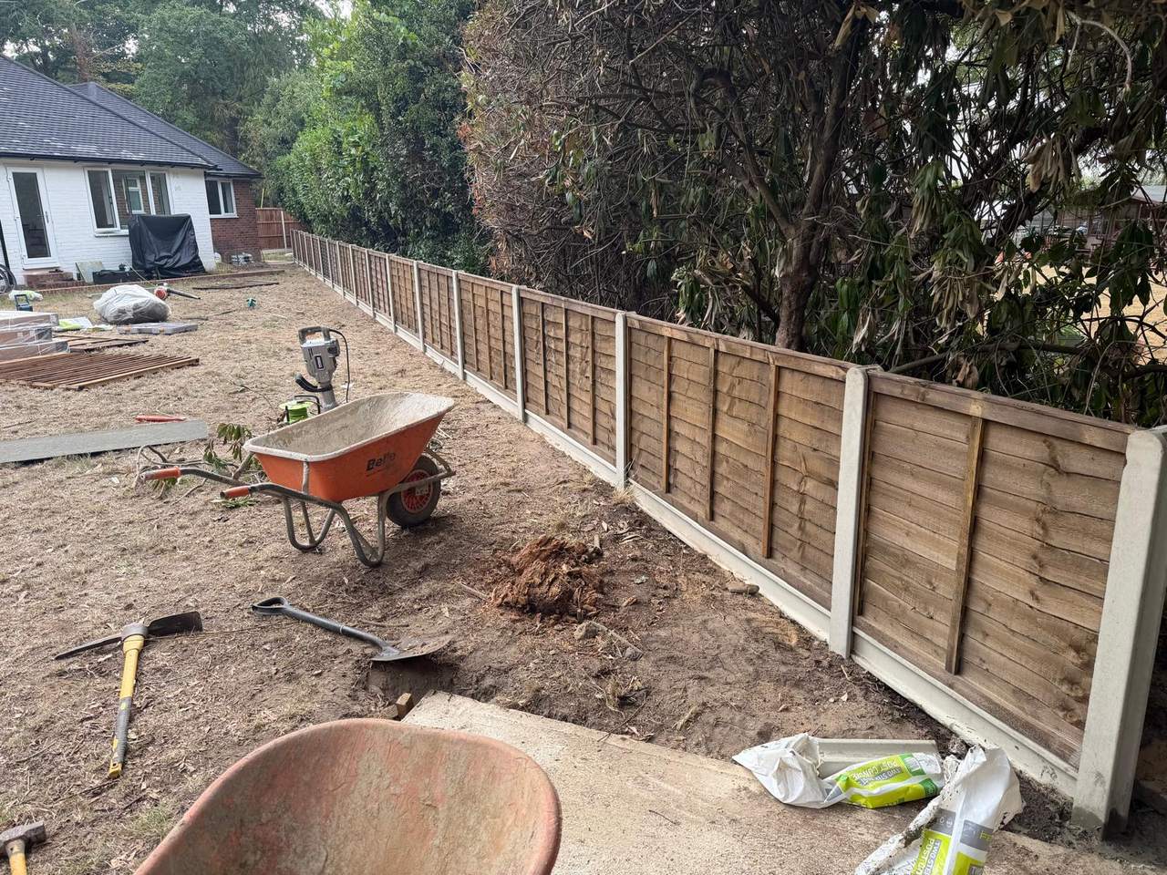 Lap fence panels going in along a boundary with the ground dug over and levelled behind