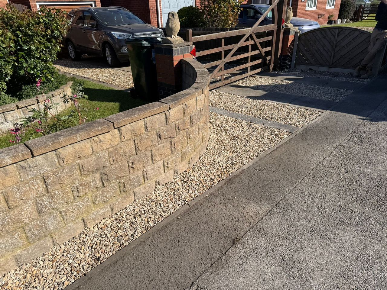 Sandstone retaining wall with gravel driveway