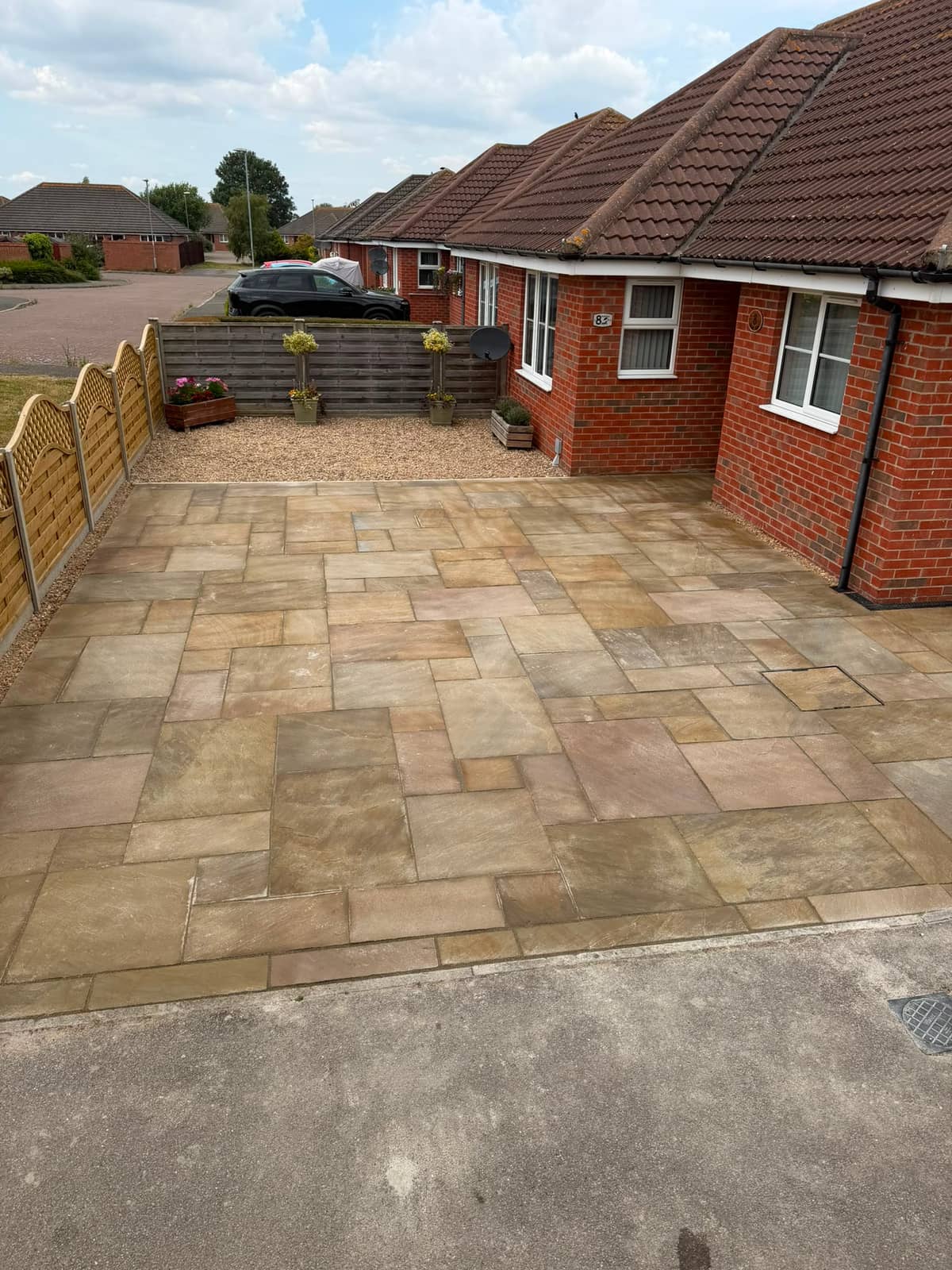 Sandstone paving running from the road up to the front door, gravel bed and planters behind